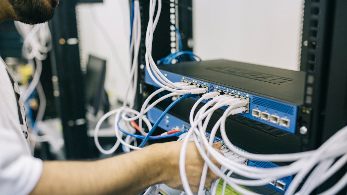 IT Techniker beim Verkabeln eines Server Racks
